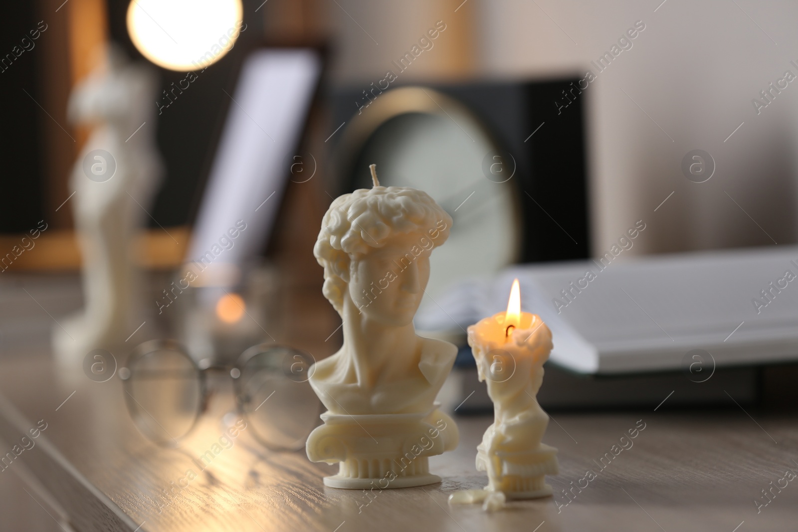 Photo of Beautiful David bust candles on table indoors