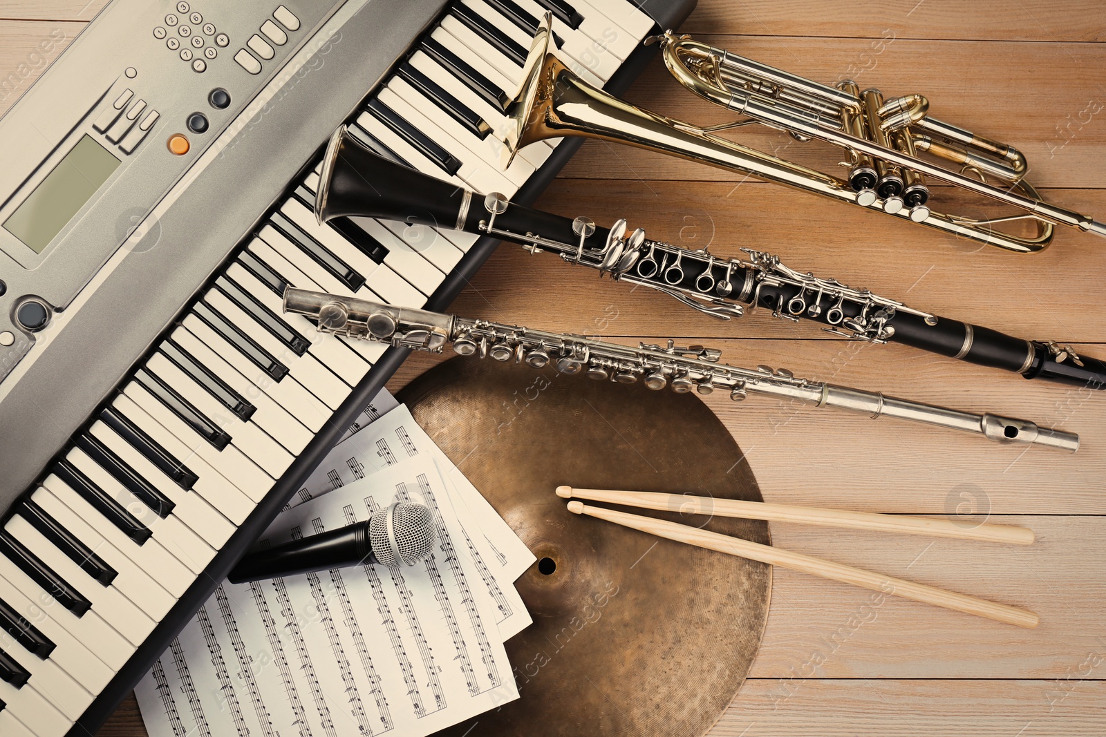 Photo of Set of different musical instruments and microphone on wooden background, flat lay