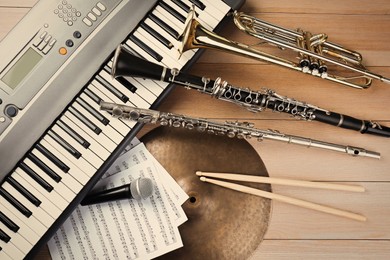 Photo of Set of different musical instruments and microphone on wooden background, flat lay