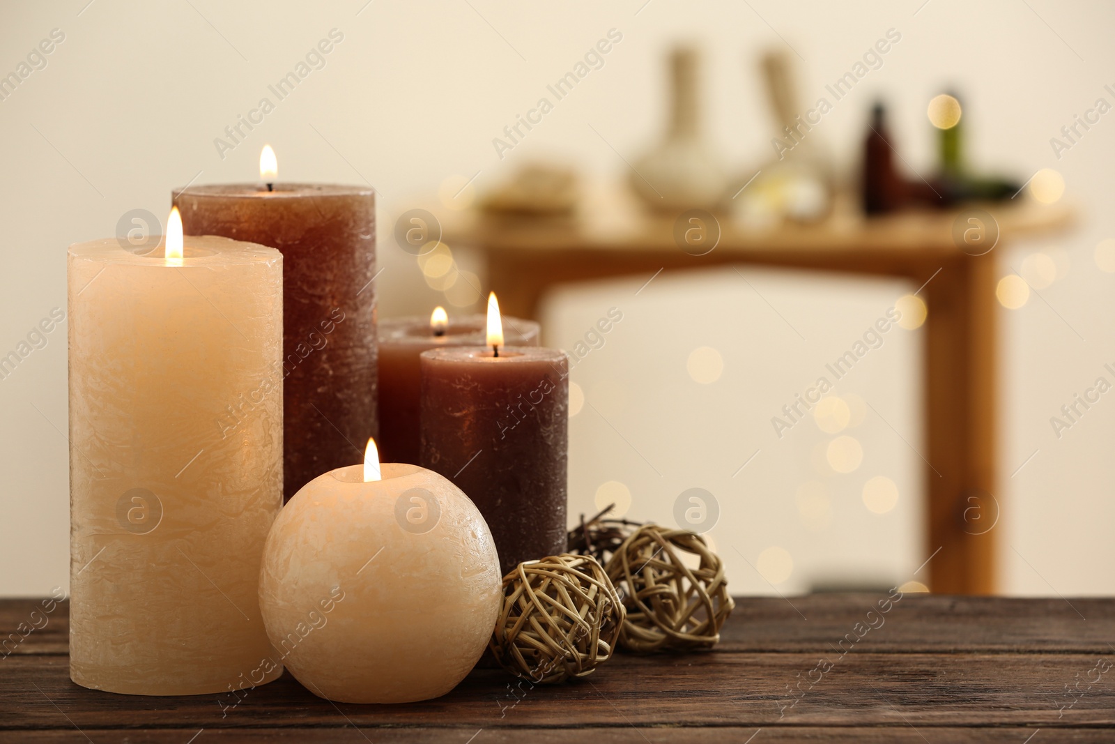 Photo of Burning candles on wooden table indoors. Space for text