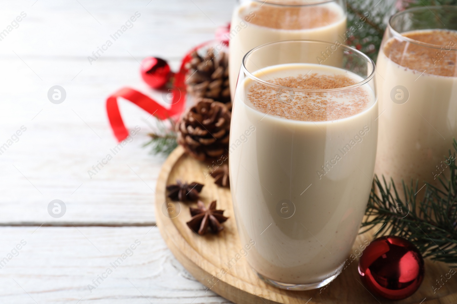 Photo of Delicious Christmas cocktail with liqueur on white wooden table, closeup. Space for text