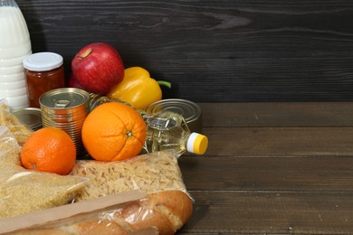 Different donation food on wooden table, closeup. Space for text