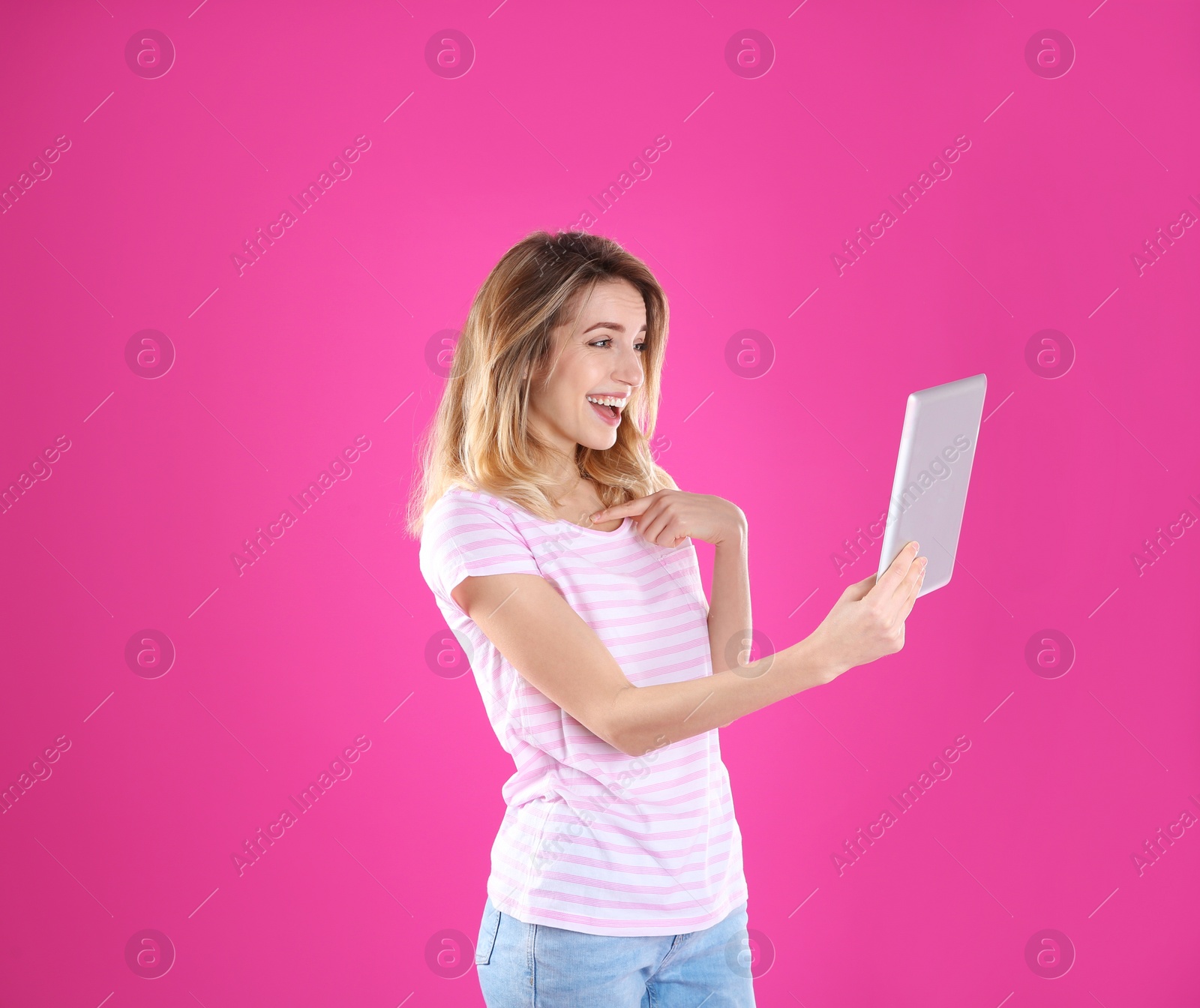 Photo of Woman using tablet for video chat on color background