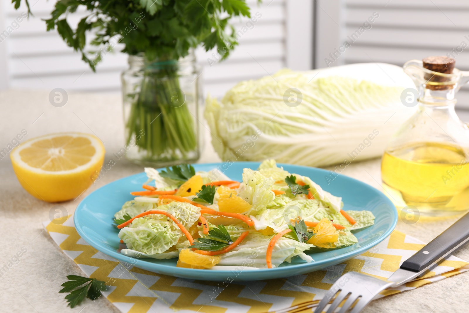 Photo of Tasty salad with Chinese cabbage, products and fork on beige table