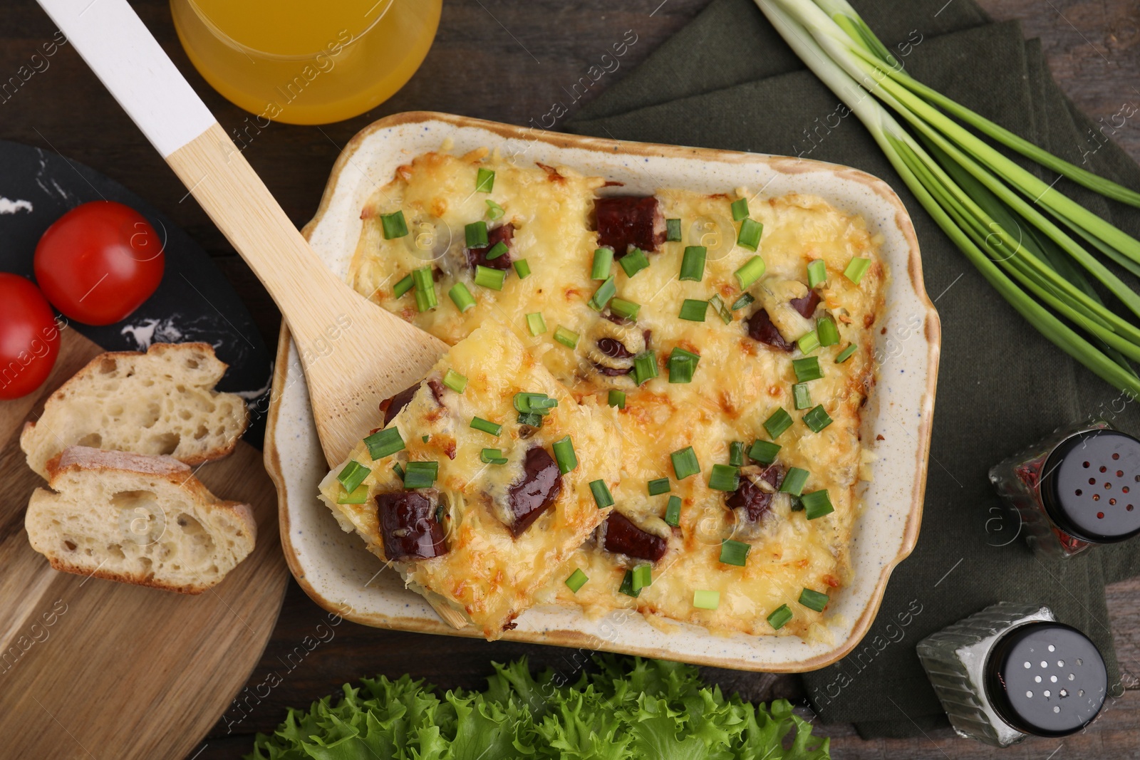 Photo of Tasty sausage casserole served on table, flat lay