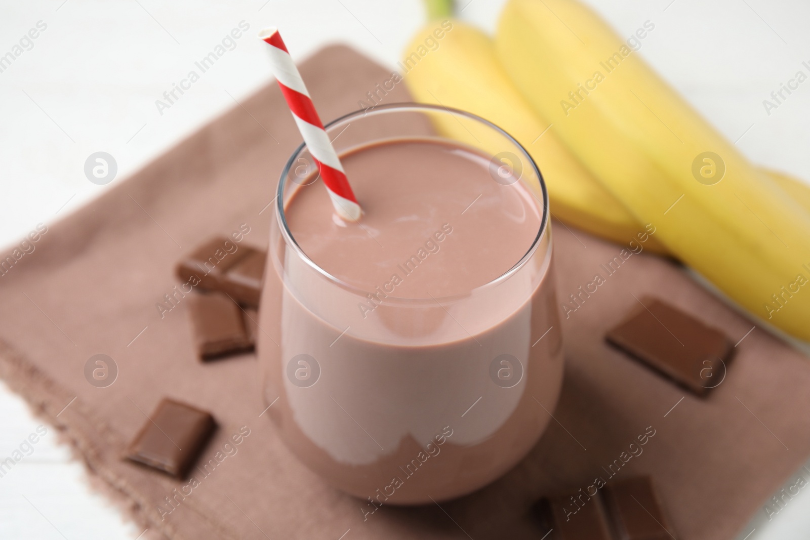 Photo of Fresh yummy chocolate milk on white table, closeup