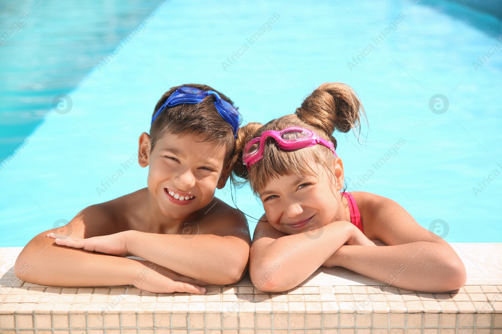 Photo of Happy children with goggles in swimming pool