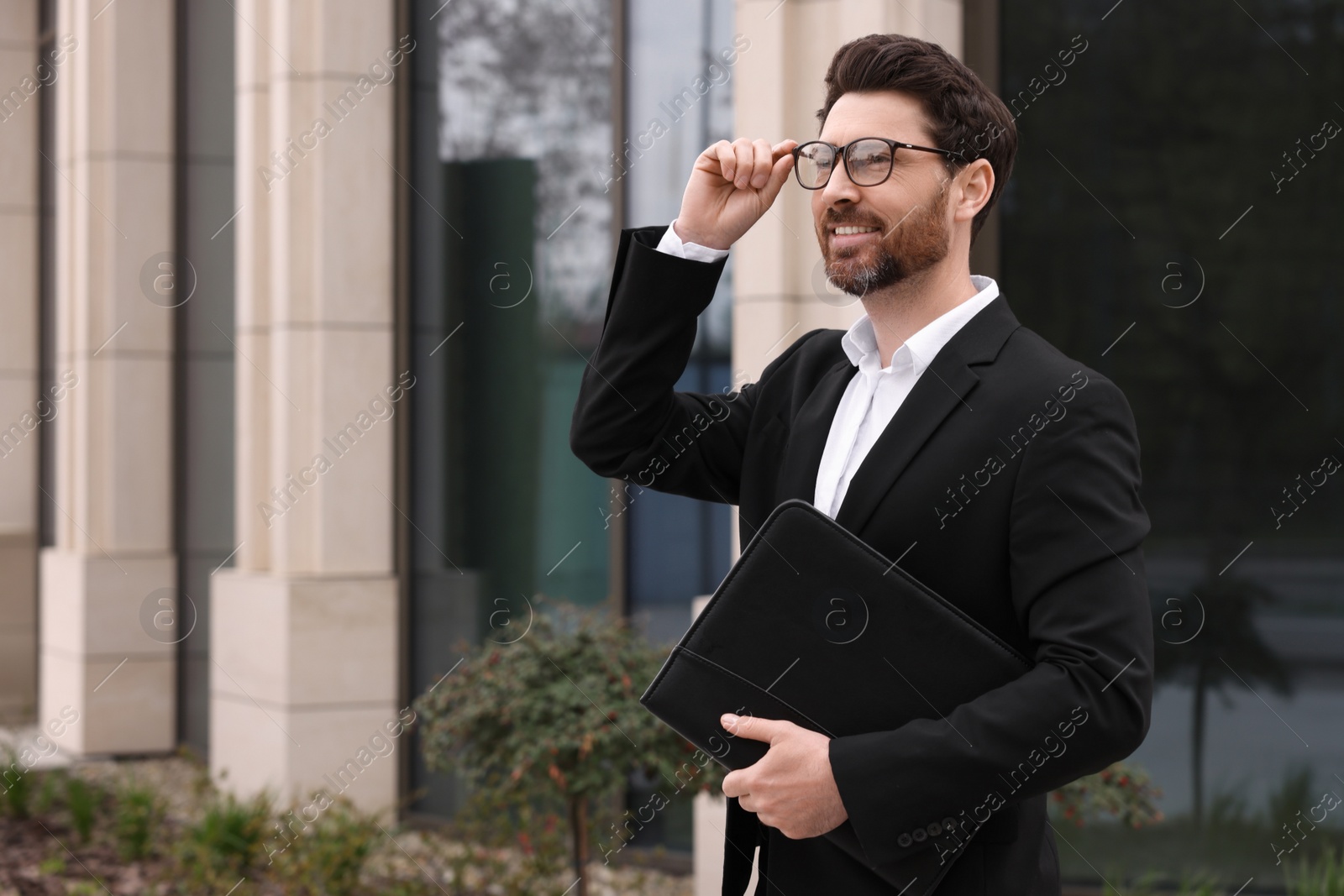 Photo of Real estate agent with leather portfolio outdoors. Space for text