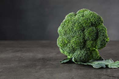 Photo of Fresh raw broccoli on grey table, closeup. Space for text