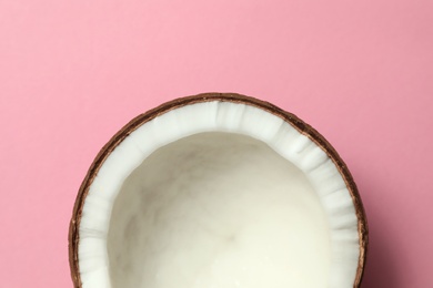 Fresh coconut half on pink background, top view