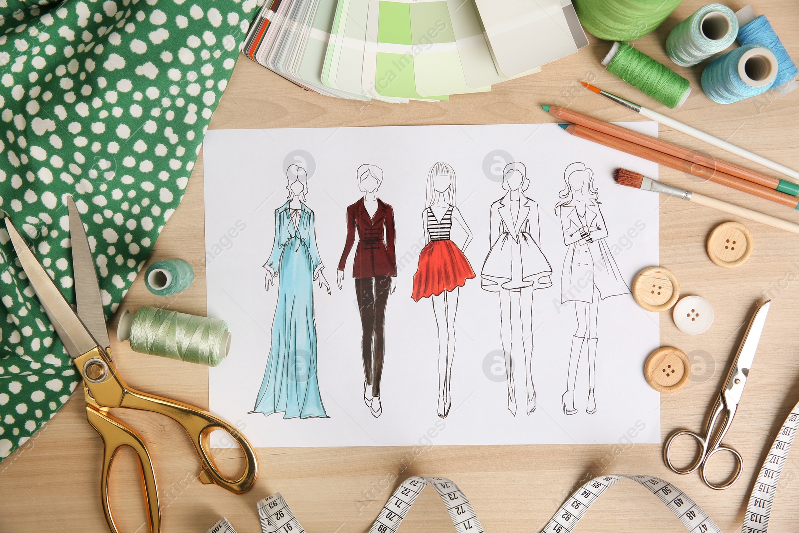 Photo of Sketch of fashion clothes and thread supplies at designer's workplace, flat lay