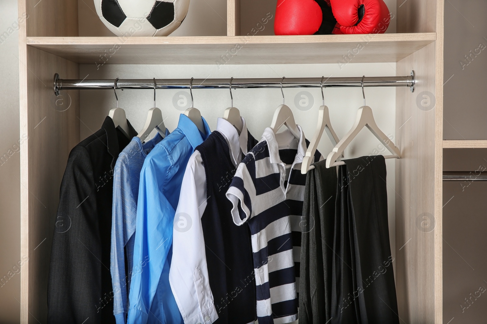 Photo of Wardrobe with stylish boy's clothes hanging on rack