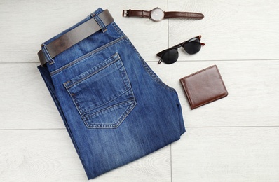 Flat lay composition with blue jeans and accessories on wooden background
