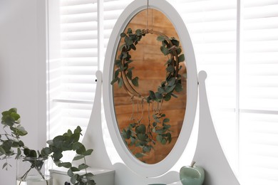 Photo of Stylish dressing table decorated with beautiful eucalyptus branches indoors