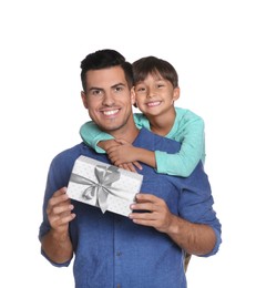 Man receiving gift for Father's Day from his son on white background