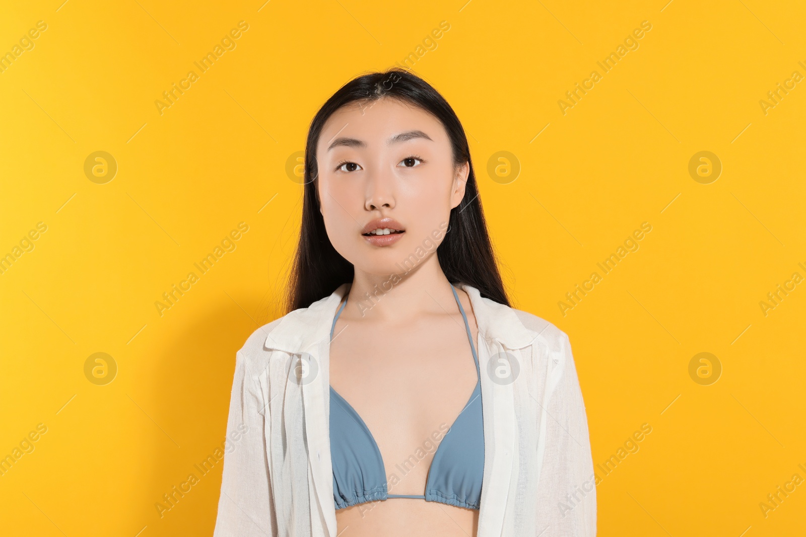 Photo of Beautiful young woman with makeup on orange background