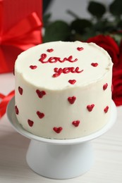 Photo of Bento cake with text Love You on white wooden table, closeup. St. Valentine's day surprise