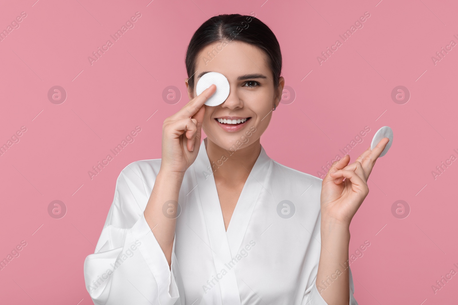 Photo of Young woman with cotton pads on pink background