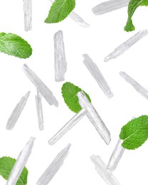 Image of Translucent menthol crystals and green mint leaves falling on white background