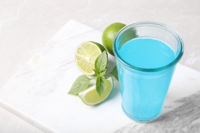 Photo of Refreshing light blue drink on white table, space for text