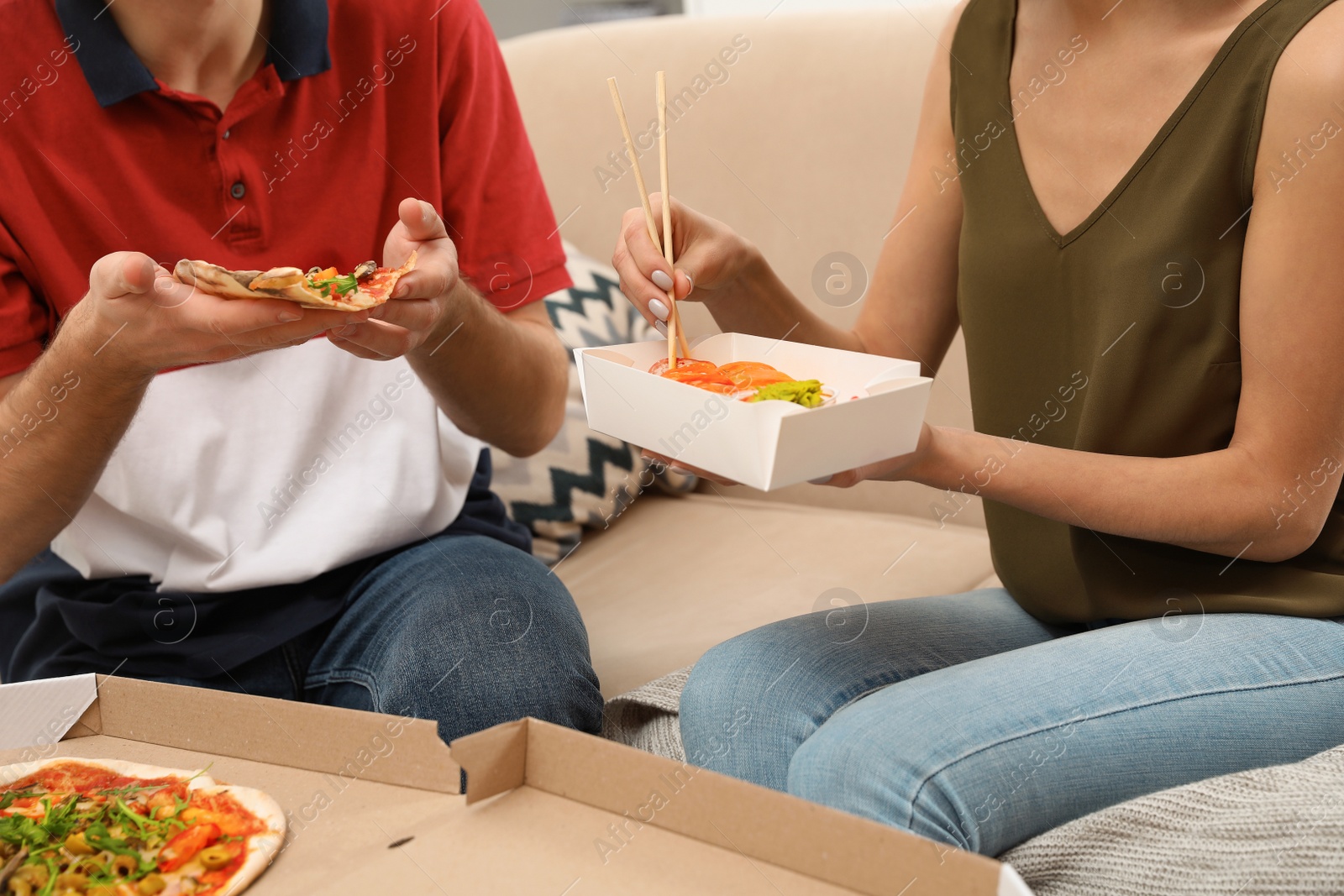 Photo of Young couple having lunch at home, closeup. Food delivery