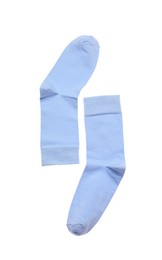 Photo of Light blue socks on white background, top view