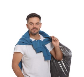 Man holding garment cover with clothes on white background. Dry-cleaning service