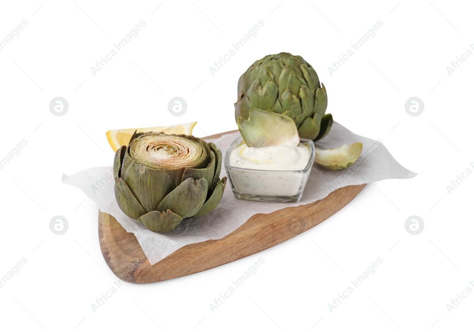 Photo of Delicious cooked artichokes with tasty sauce isolated on white