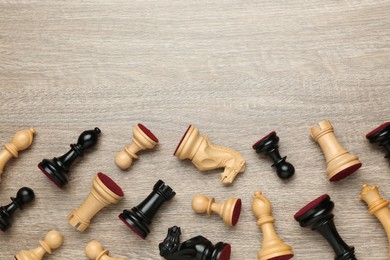 Photo of Many different chess pieces on wooden table, flat lay. Space for text