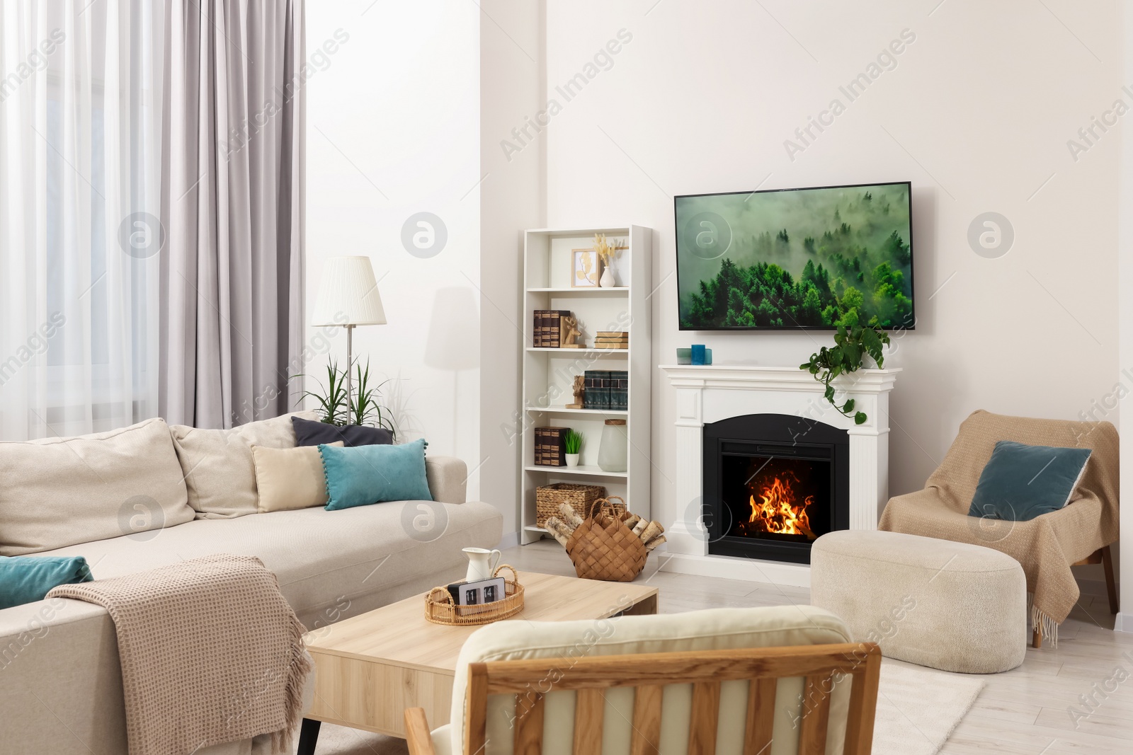 Photo of Stylish living room interior with cozy sofa, table, TV set and fireplace