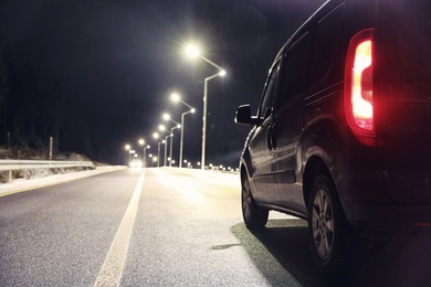 Modern car on asphalt road at night