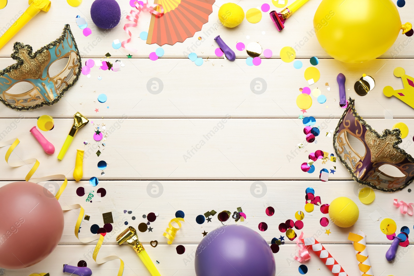 Photo of Frame of carnival items on white wooden background, flat lay. Space for text