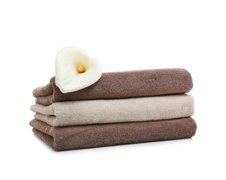 Stack of clean folded towels with flower on white background