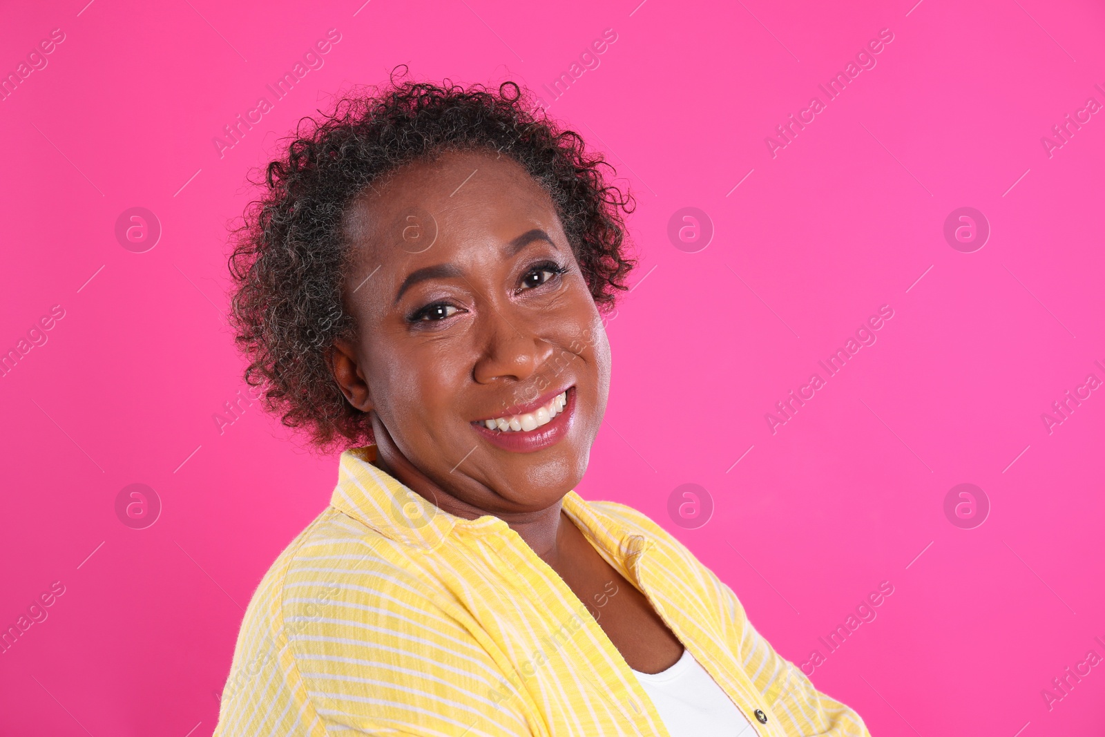 Photo of Portrait of happy African-American woman on pink background