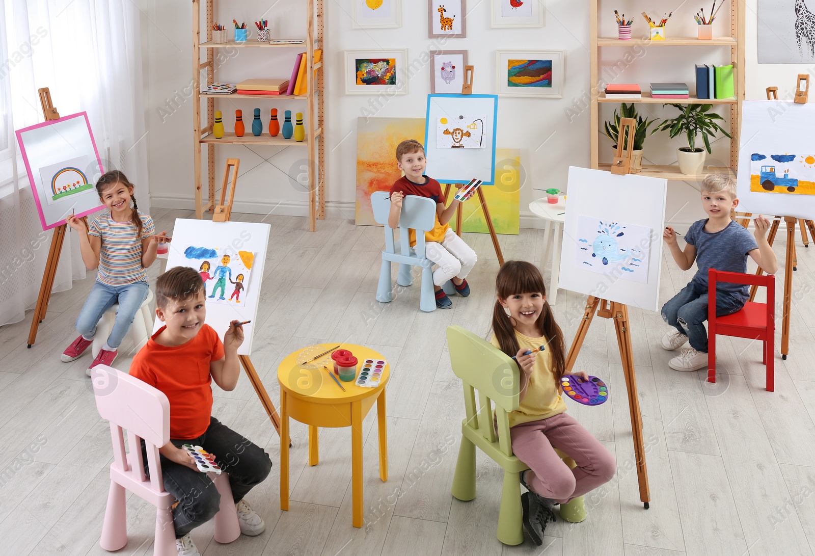 Photo of Cute little children painting during lesson in room