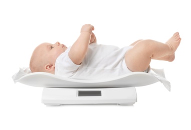 Cute little baby lying on scales against white background