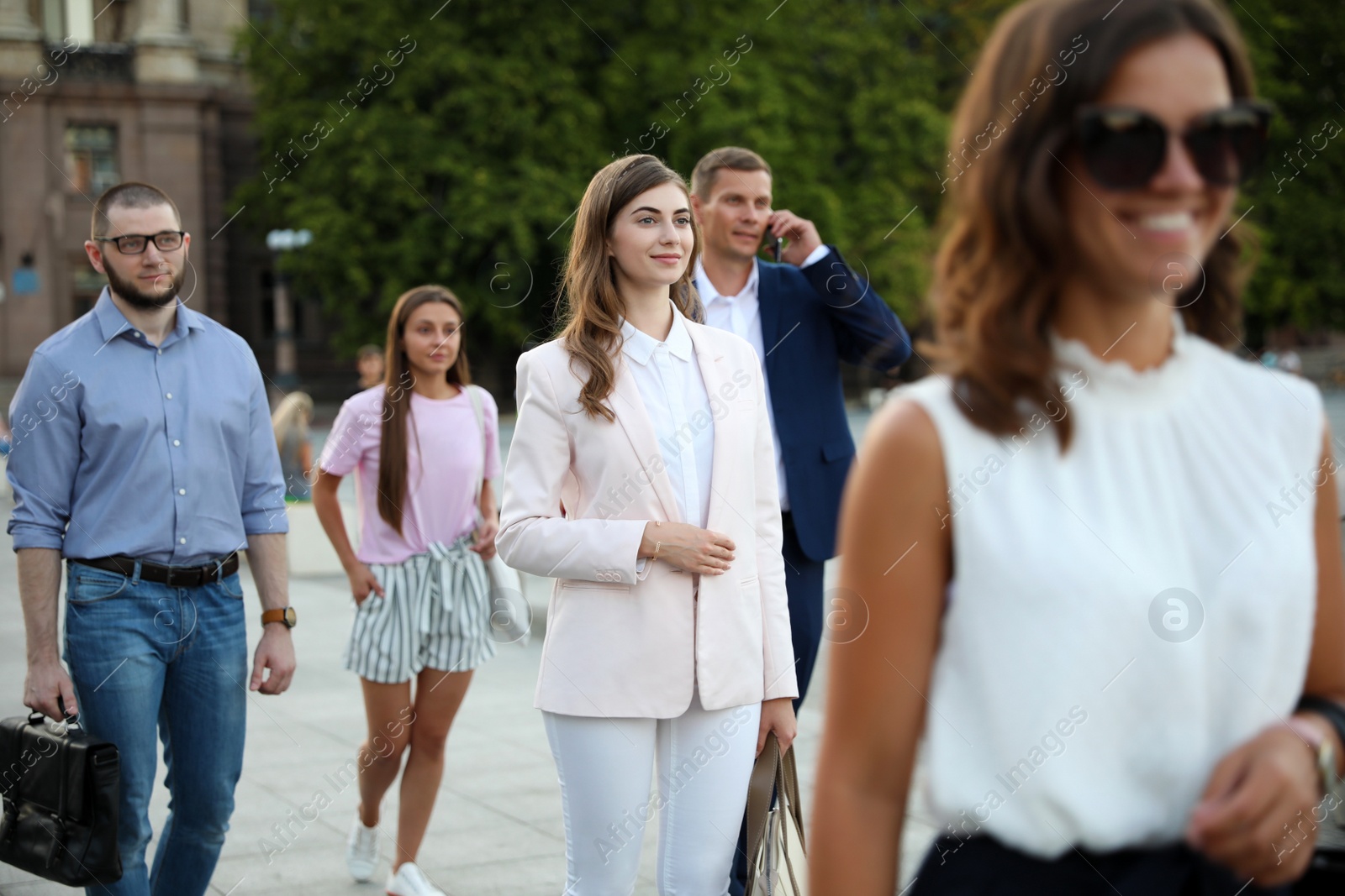 Photo of Different people walking on modern city street