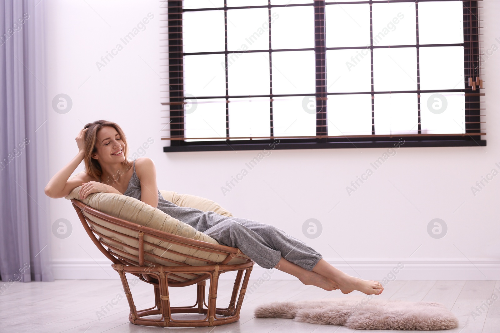 Photo of Young woman relaxing near window with blinds at home. Space for text