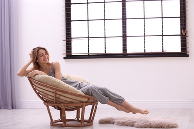 Photo of Young woman relaxing near window with blinds at home. Space for text