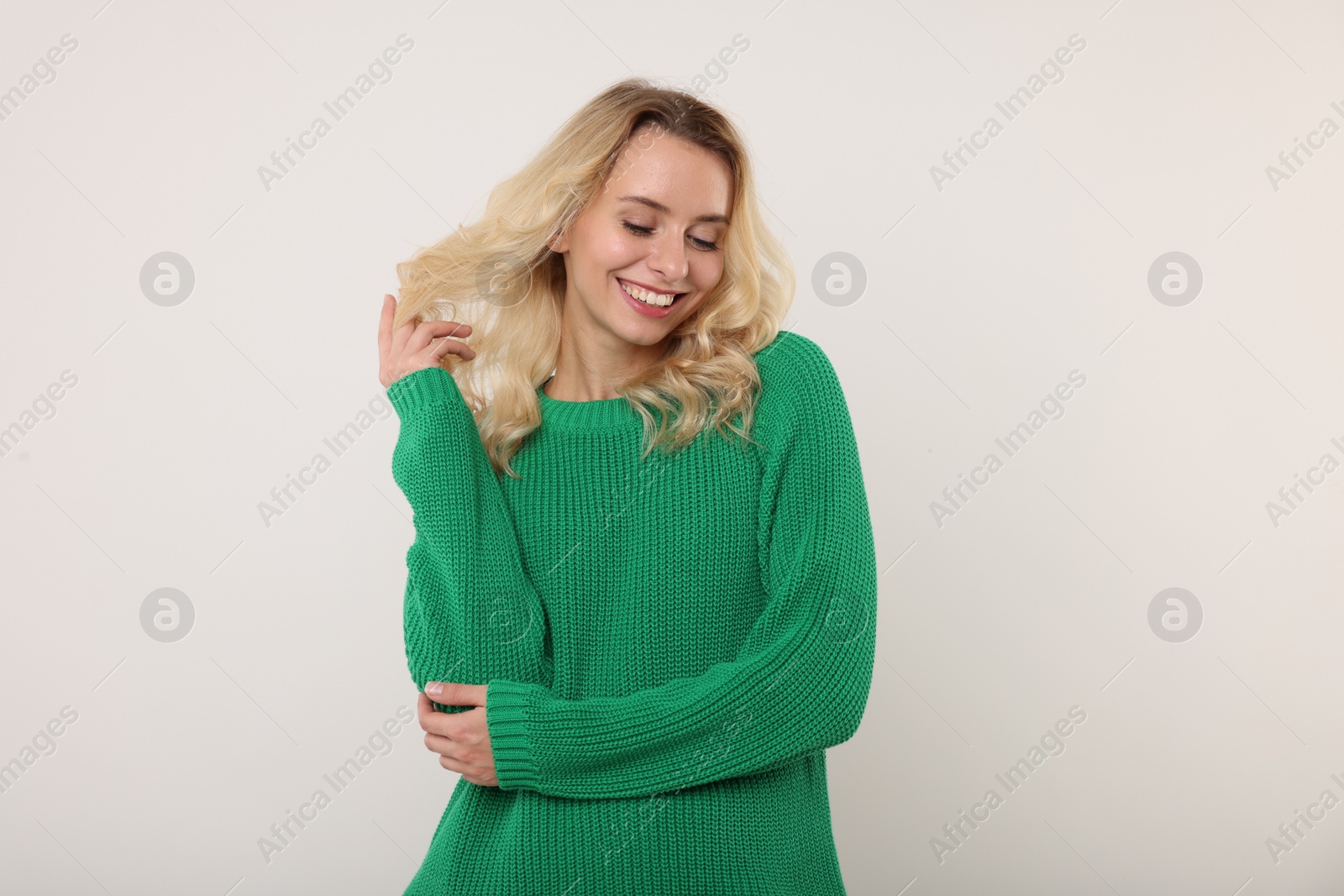 Photo of Happy woman in stylish warm sweater on white background