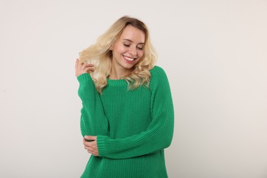 Happy woman in stylish warm sweater on white background