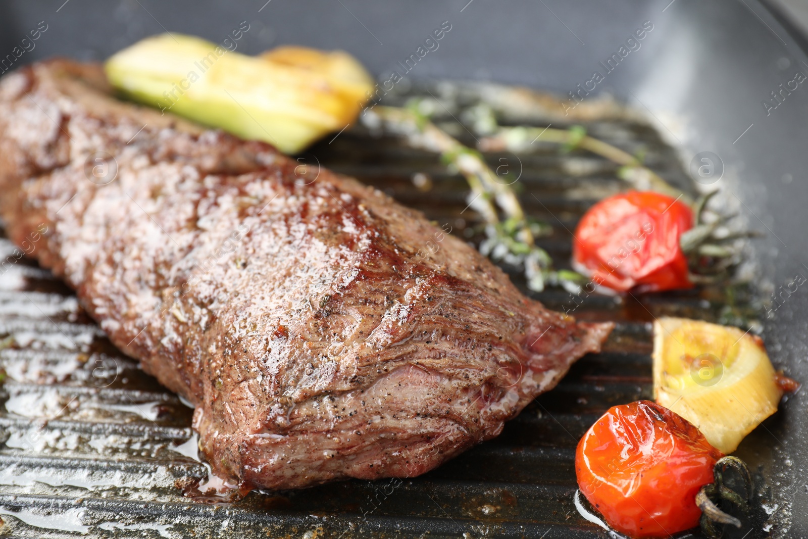 Photo of Delicious grilled beef meat and vegetables in pan, closeup