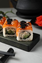 Photo of Delicious sushi rolls served on light grey table
