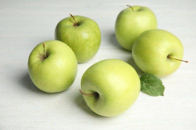 Photo of Fresh ripe green apples on white wooden table