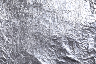 Photo of Crumpled silver foil as background, closeup view