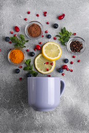 Photo of Cup and ingredients for immunity boosting tea on grey table, flat lay
