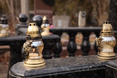 Photo of Grave lanterns on granite surface at cemetery