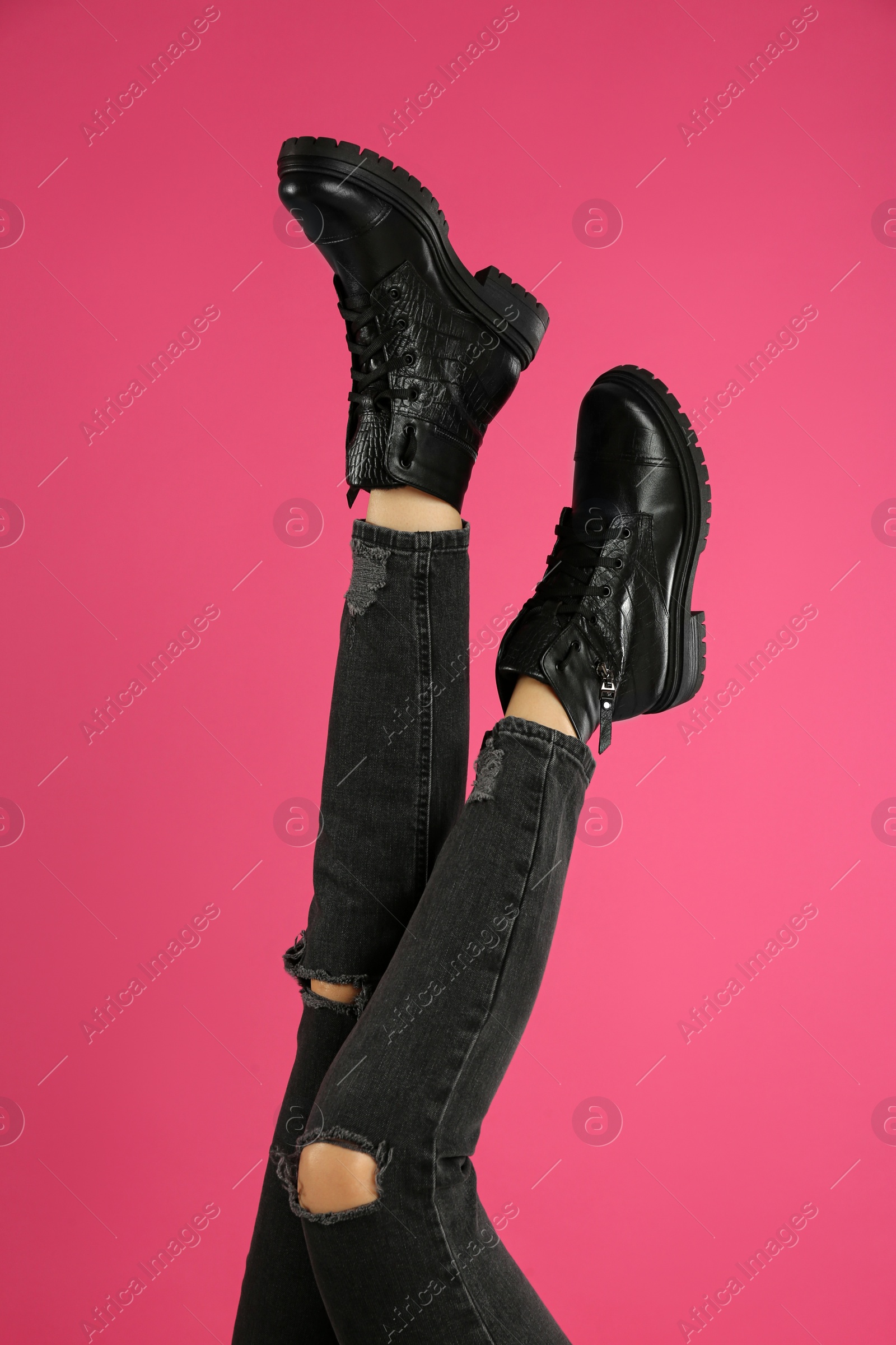 Photo of Woman wearing stylish boots on pink background, closeup