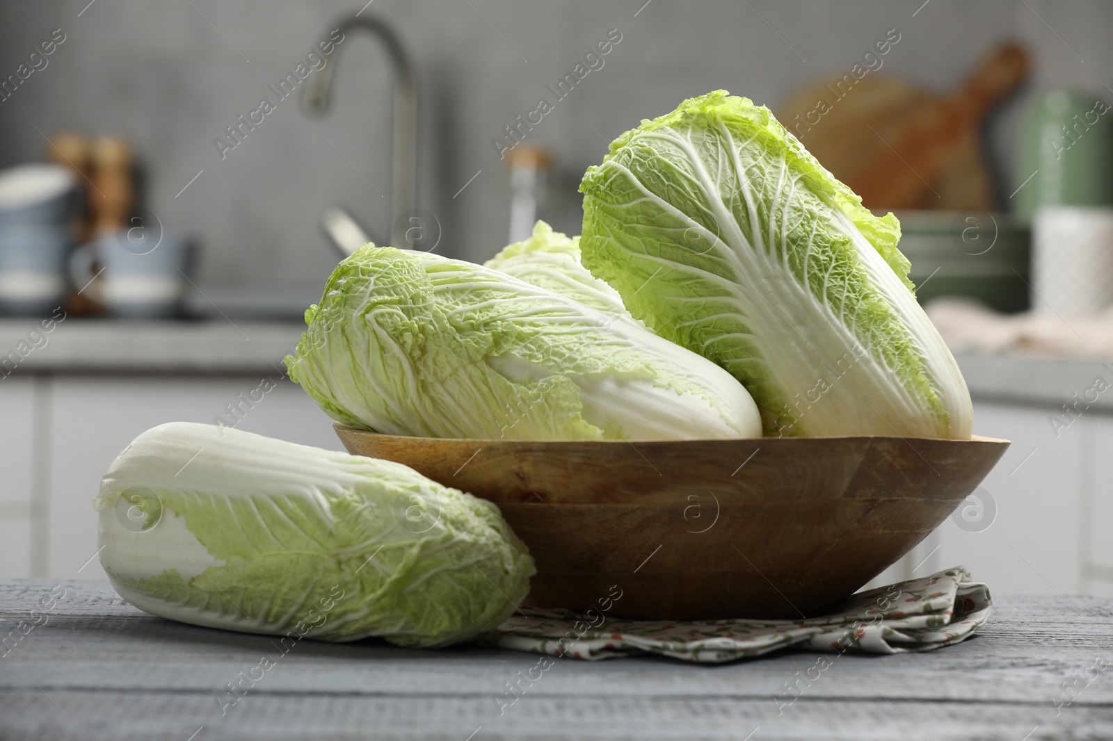 Photo of Fresh Chinese cabbages on grey wooden table