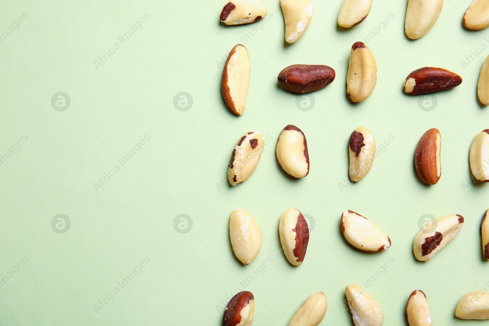 Photo of Flat lay composition with Brazil nuts and space for text on color background